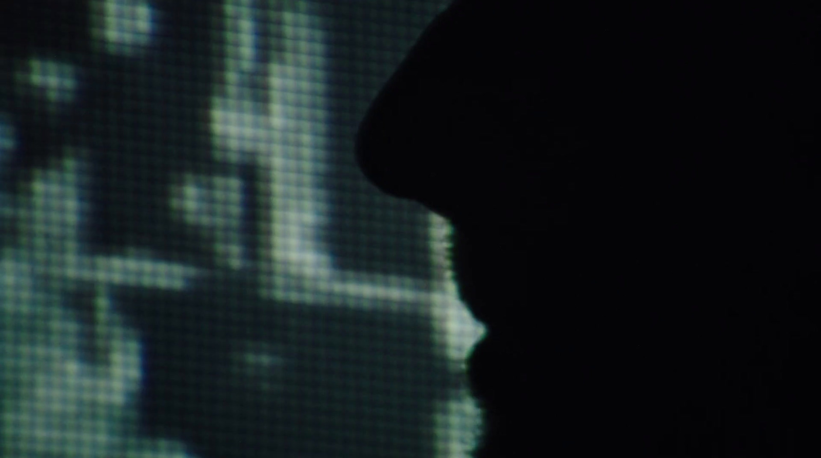 a silhouette of a person in front of a screen