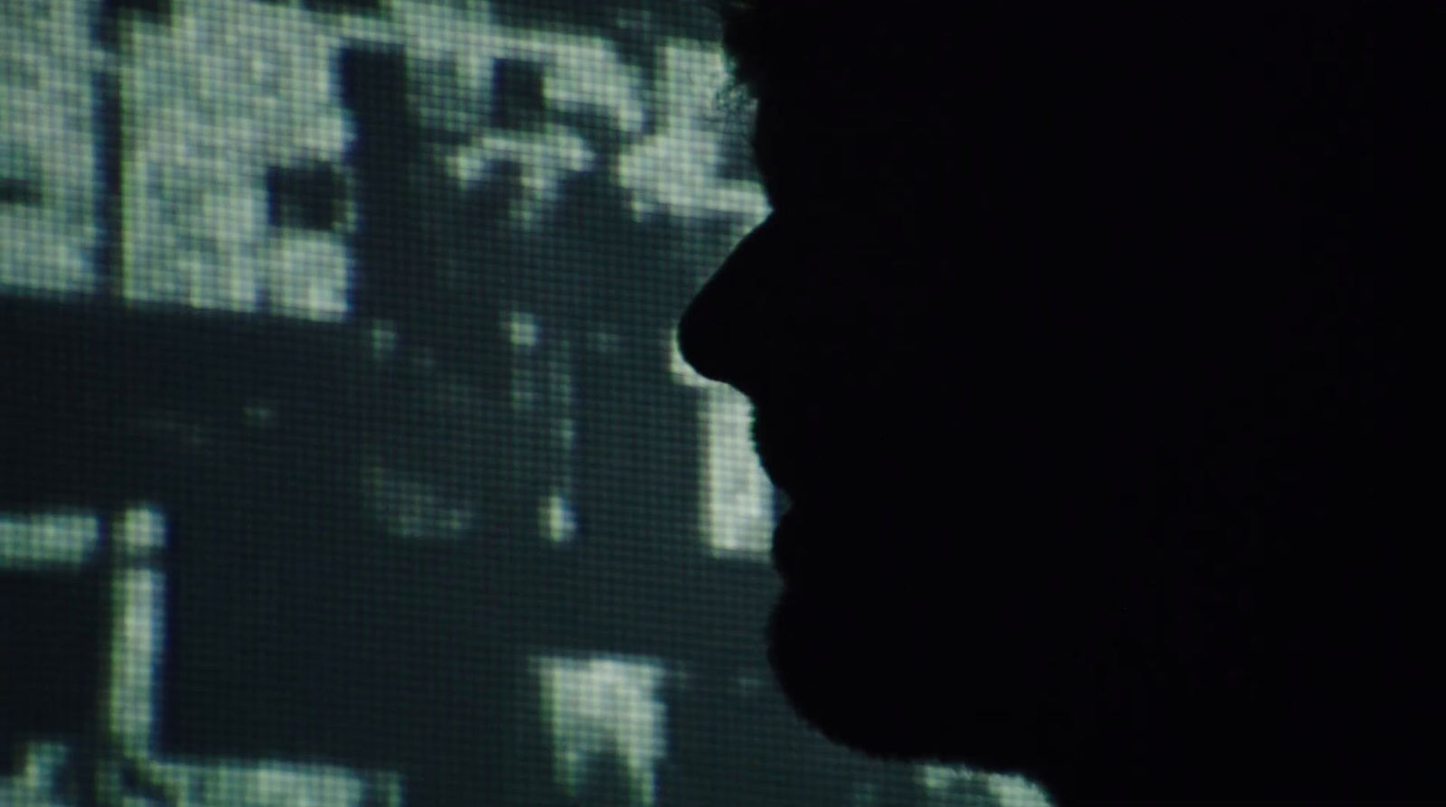 a silhouette of a person in front of a screen