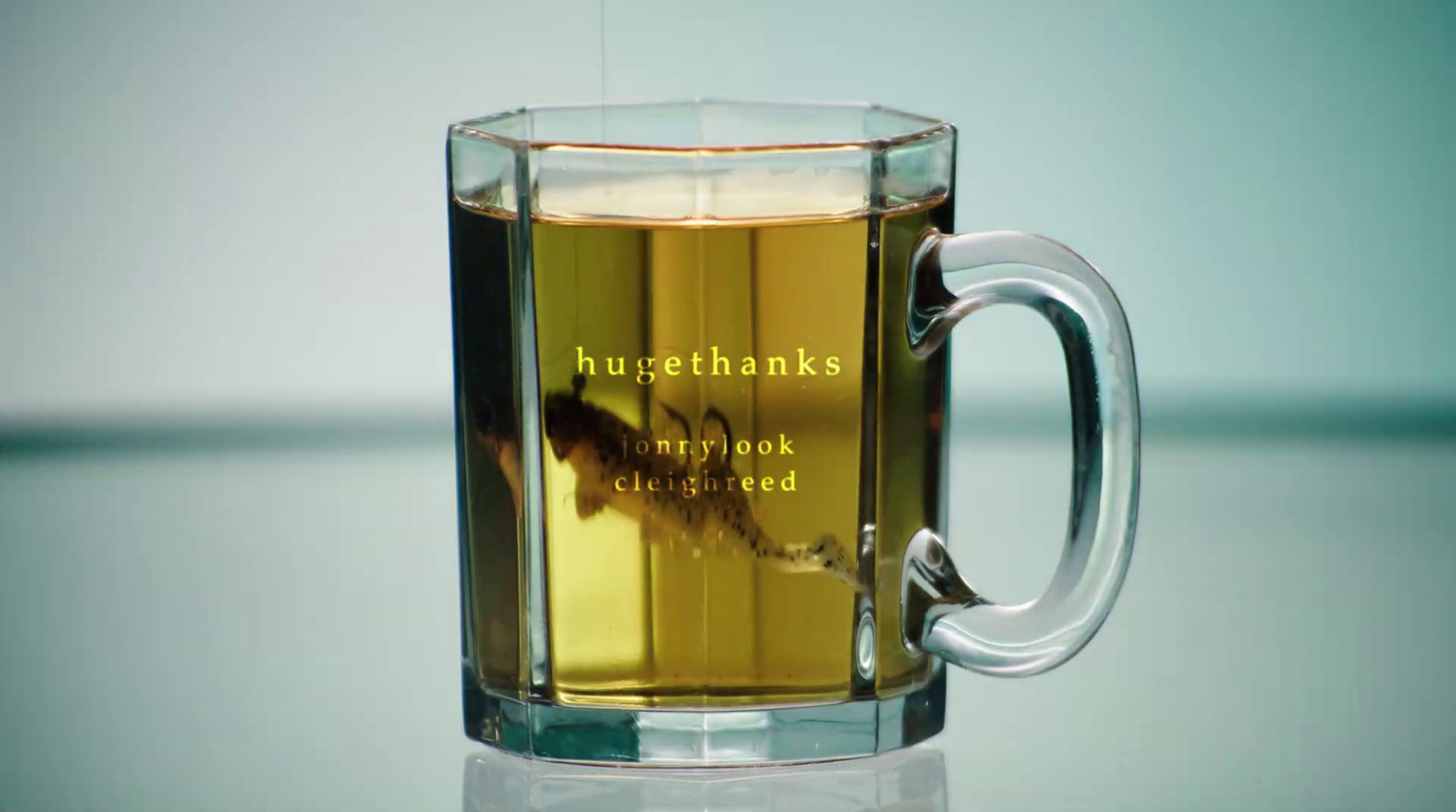 a glass mug filled with liquid sitting on top of a table