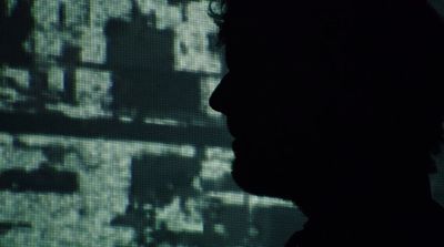 a silhouette of a man in front of a screen