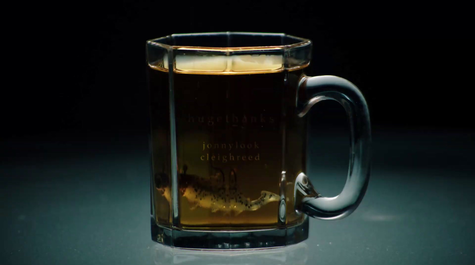 a glass mug filled with liquid sitting on a table