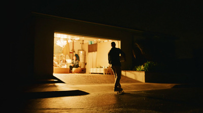 a man riding a skateboard down a street at night