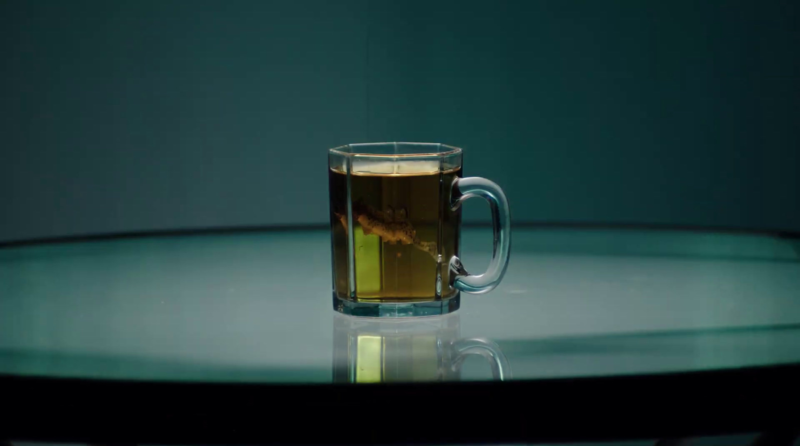 a glass cup of tea sitting on top of a table