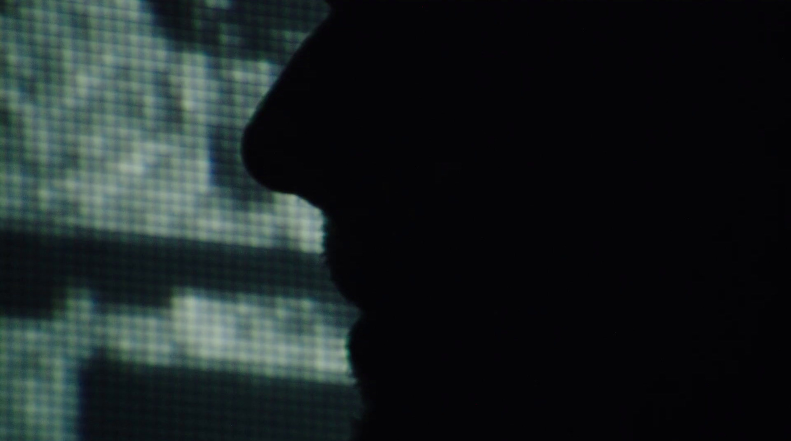 a silhouette of a person in front of a screen