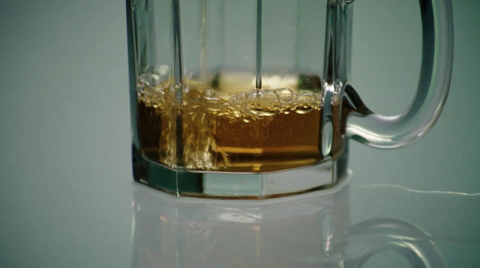 a glass mug filled with liquid on top of a table