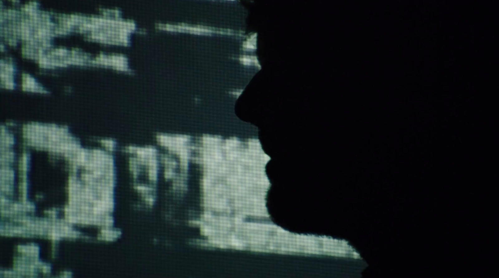 a silhouette of a man in front of a screen