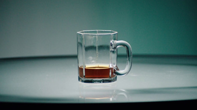 a glass mug filled with liquid sitting on a table