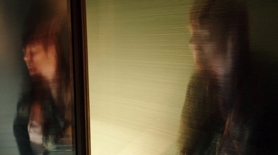 a blurry image of a woman standing in front of a window