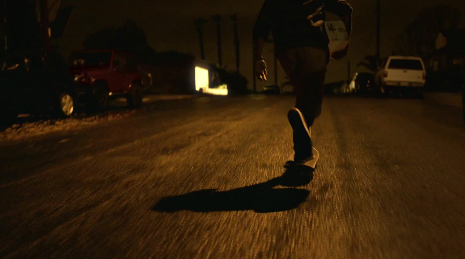 a person riding a skateboard down a street at night