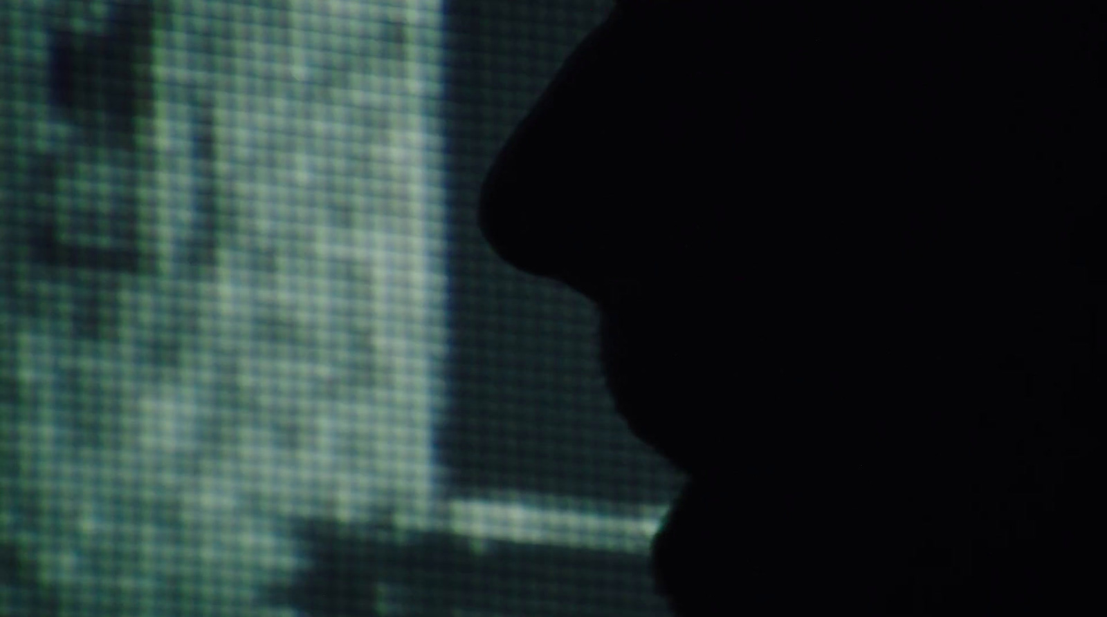 a silhouette of a person in front of a screen