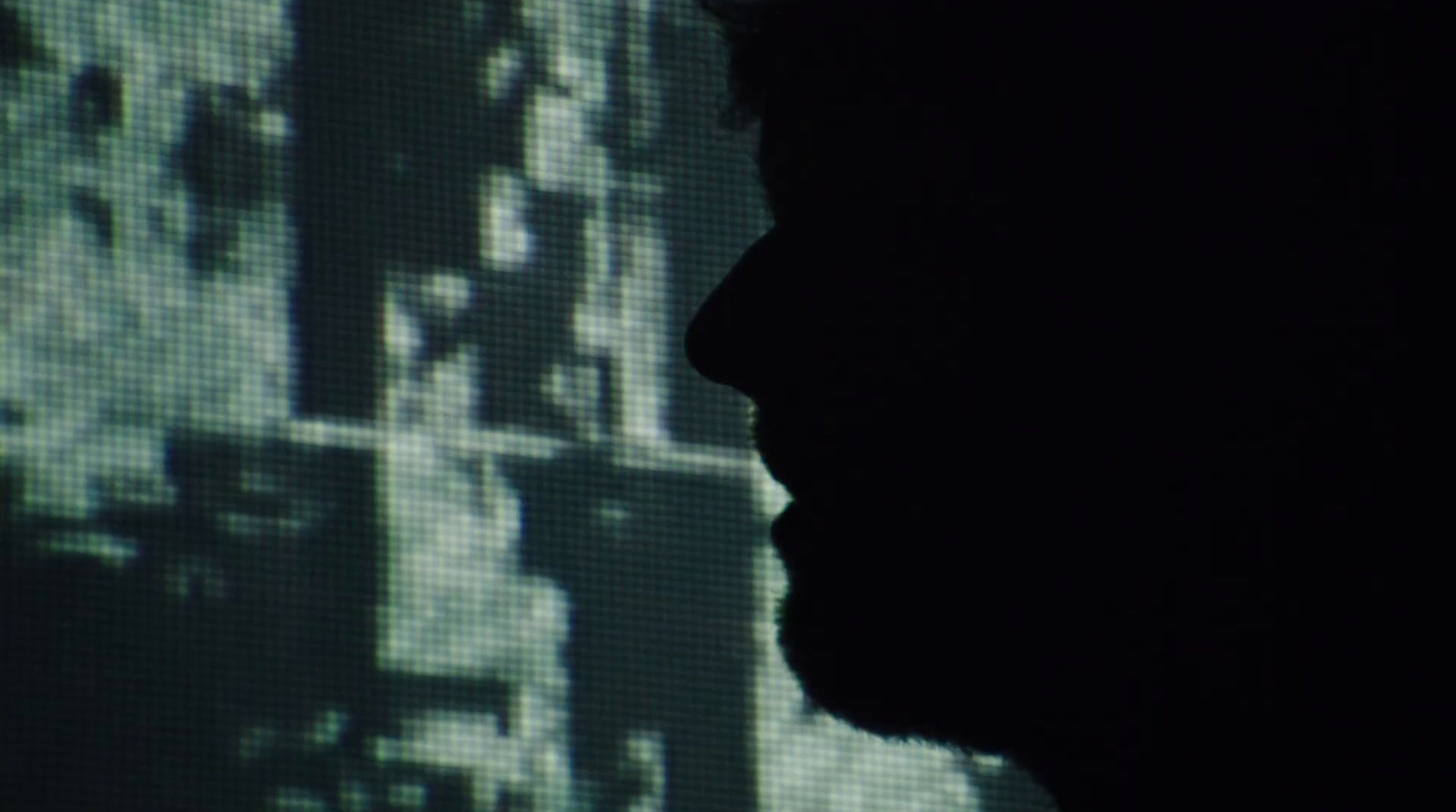 a silhouette of a man in front of a television screen