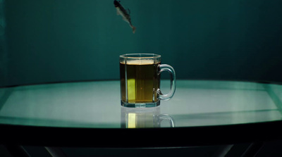 a glass of tea on a table with a fish in the background