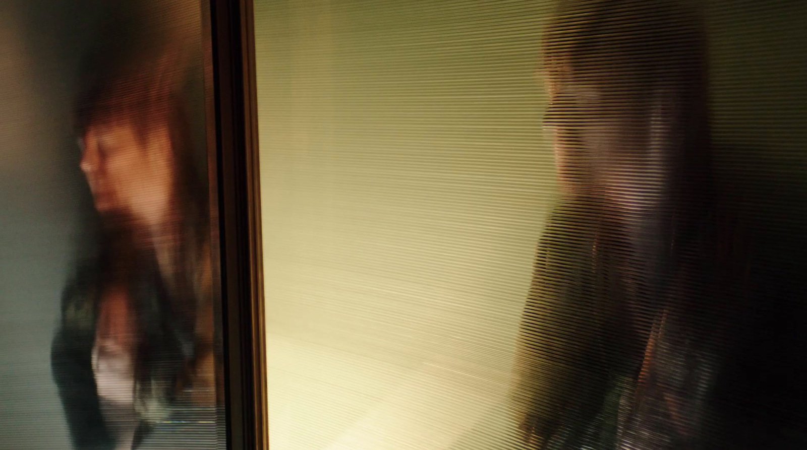 a blurry image of a woman standing in front of a window