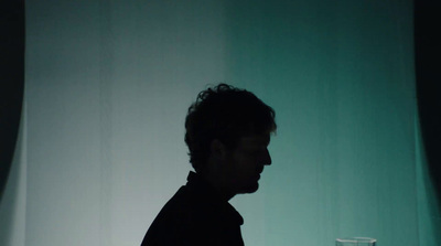 a man standing in front of a glass of water