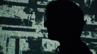 a silhouette of a man in front of a screen