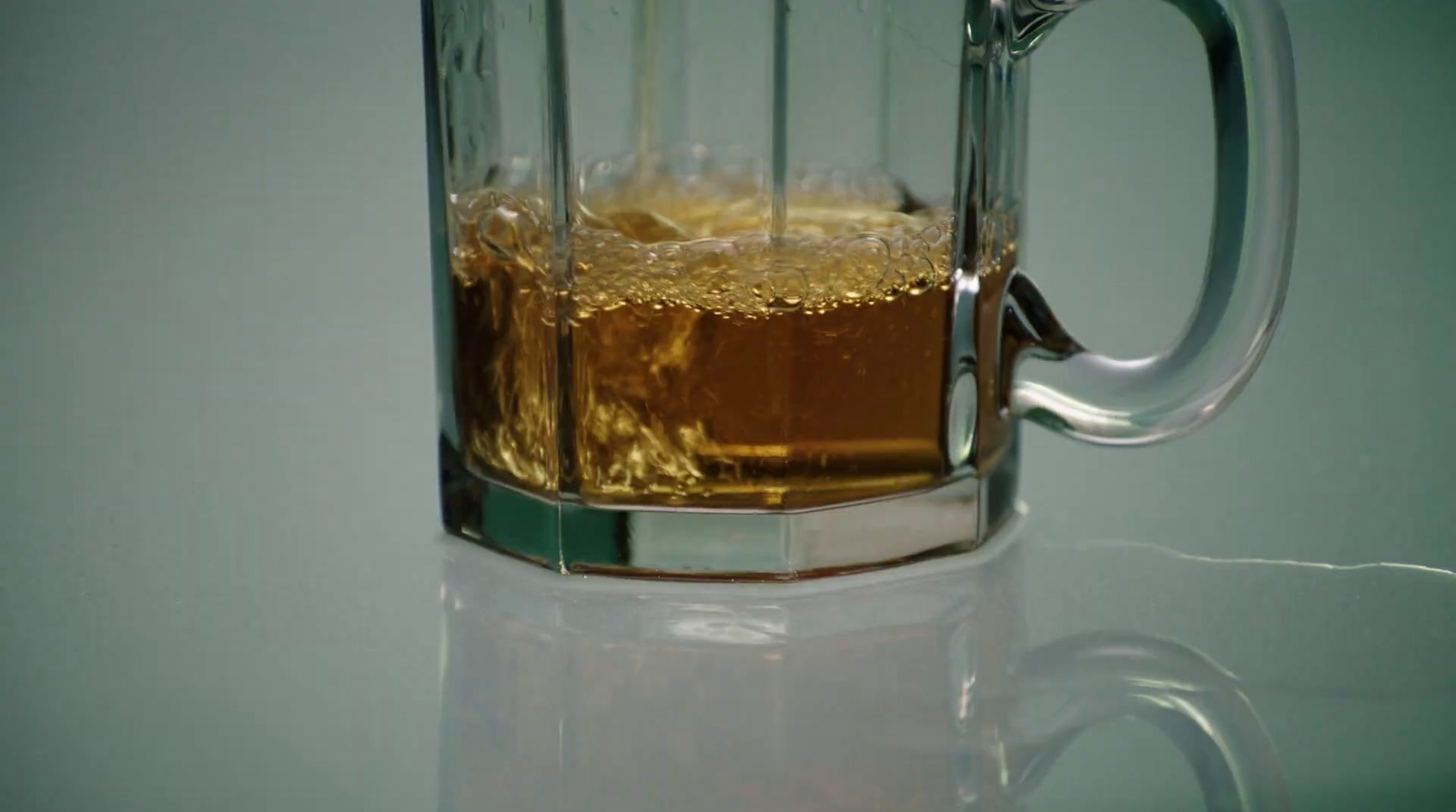 a glass mug filled with liquid on top of a table