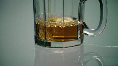 a glass mug filled with liquid on top of a table