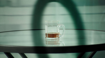 a glass of liquid sitting on top of a table