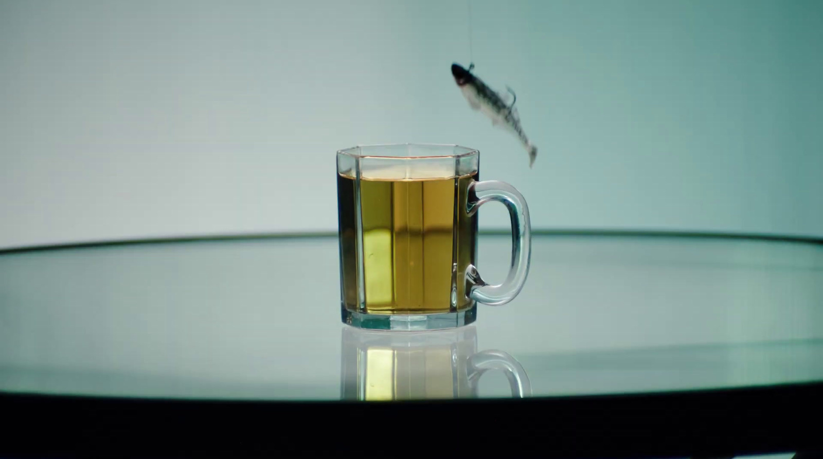 a fish flies over a glass of tea