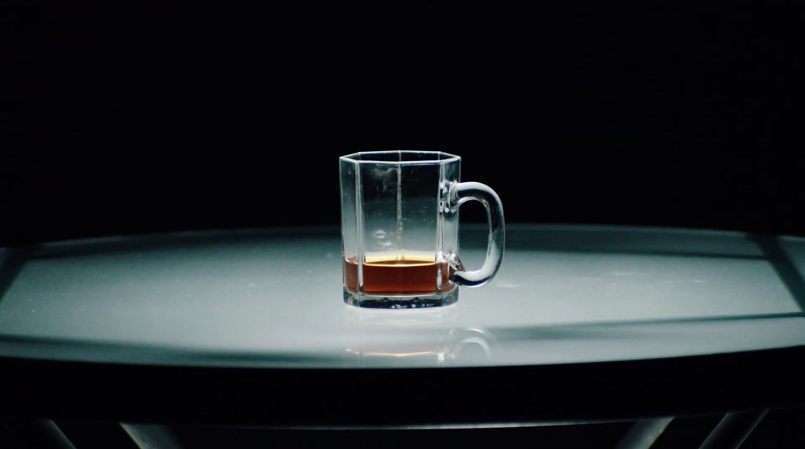 a glass of beer sitting on top of a table