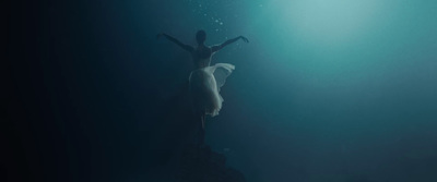 a woman standing on top of a rock under water