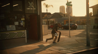 a man walking down a sidewalk with a baseball bat in his hand