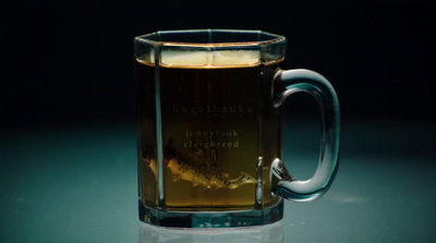 a glass mug filled with liquid sitting on a table