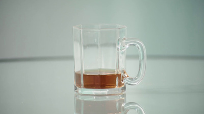 a glass of liquid sitting on top of a table