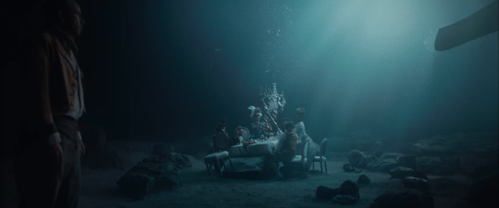 a group of people sitting around a table under water