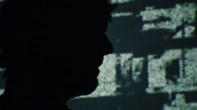 a silhouette of a man in front of a screen