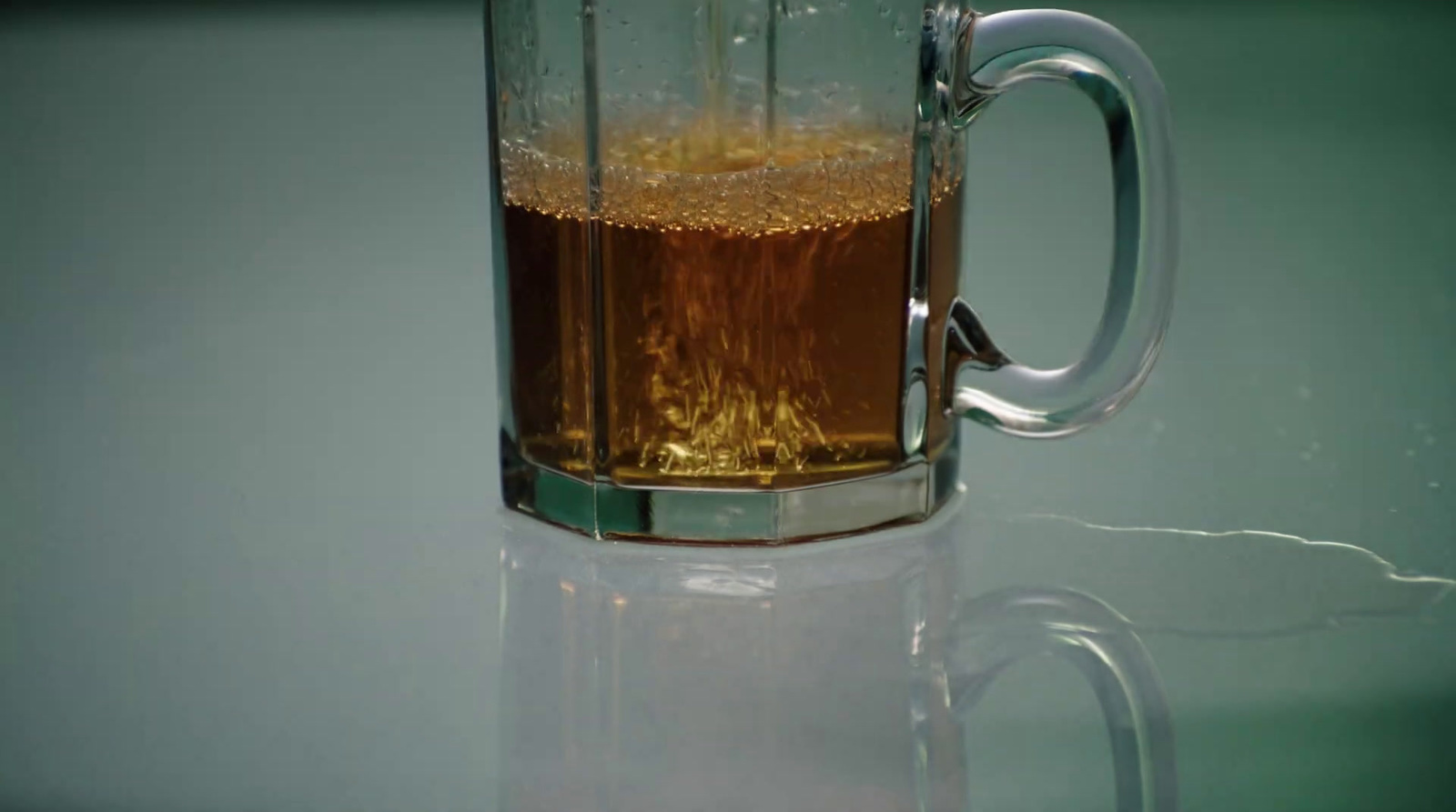 a glass mug filled with liquid on top of a table