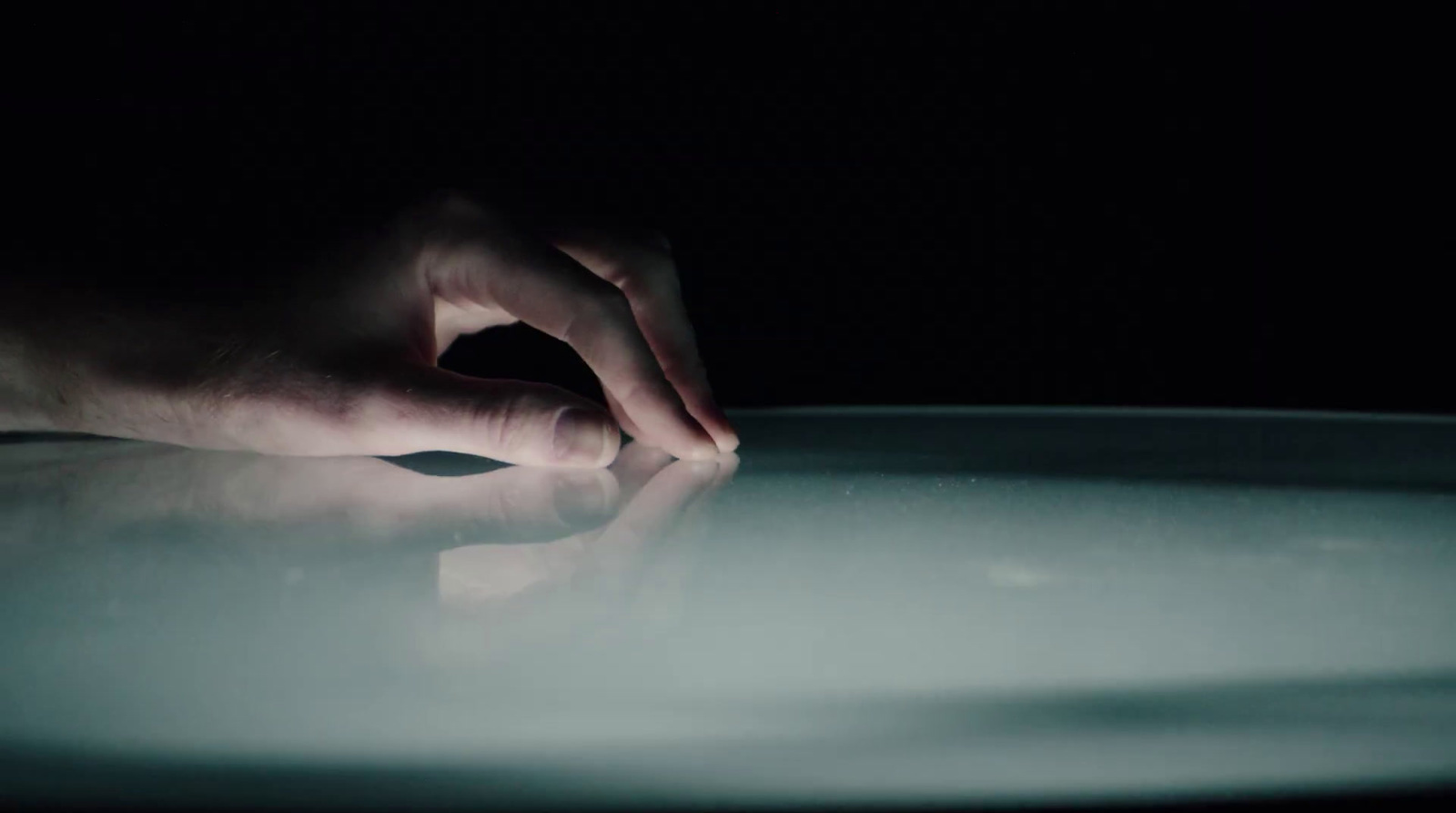 a person's hand on a table in the dark