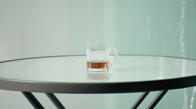 a glass of alcohol sitting on top of a table