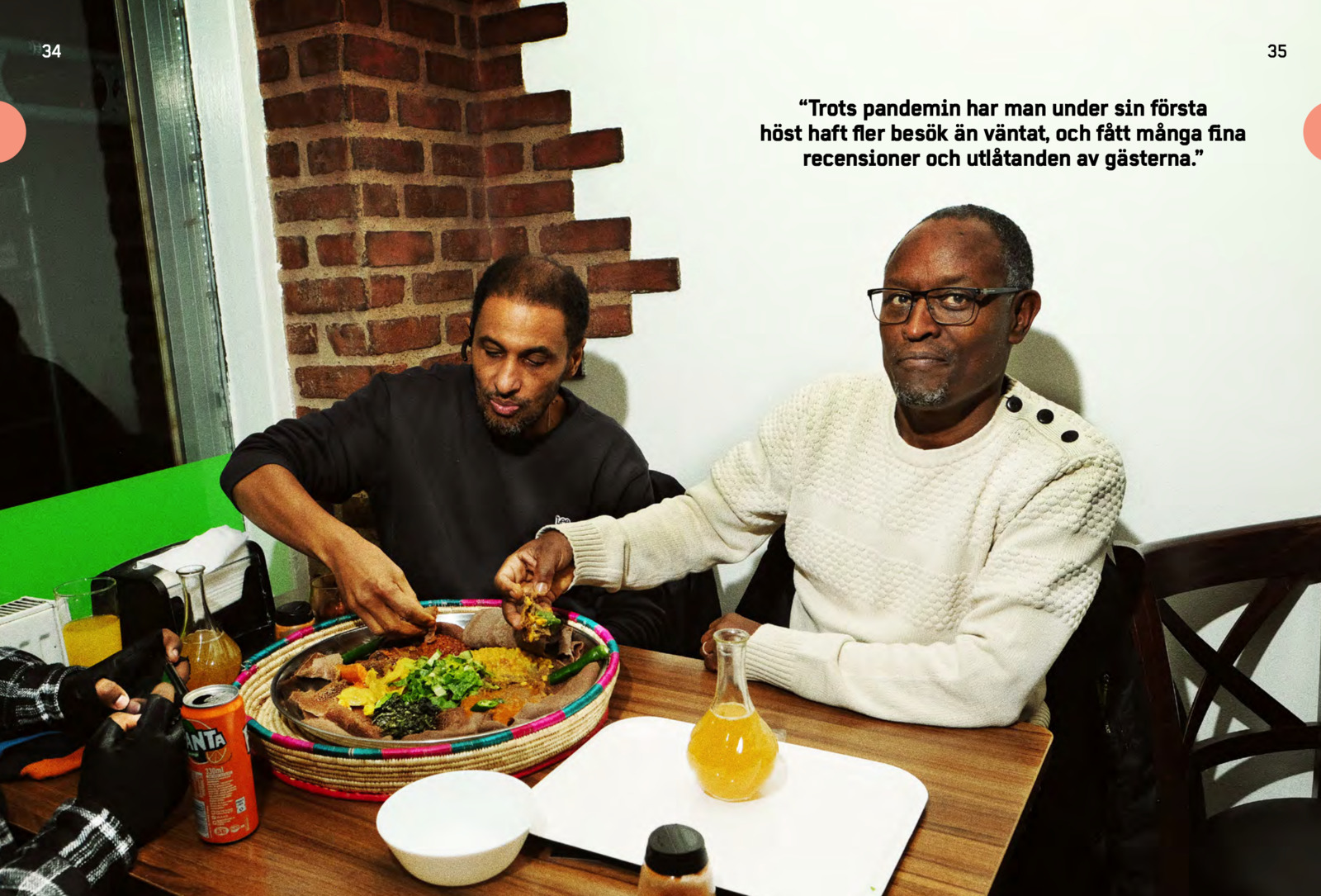 two men sitting at a table eating food