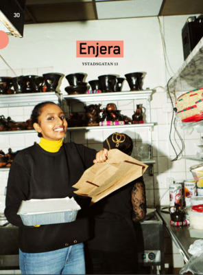 a woman holding a paper bag in a kitchen