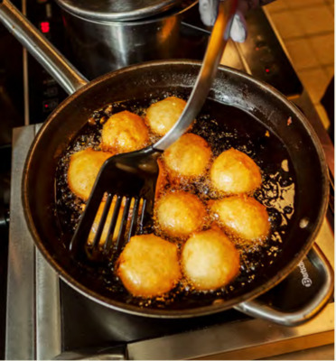 a frying pan filled with fried food on top of a stove