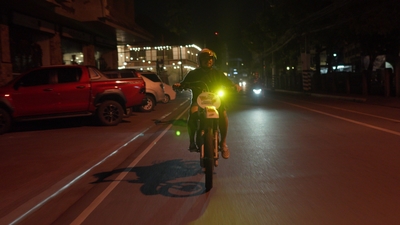 a man riding a bike down a street at night