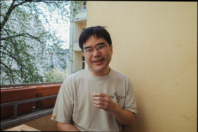 a man standing next to a building holding a glass