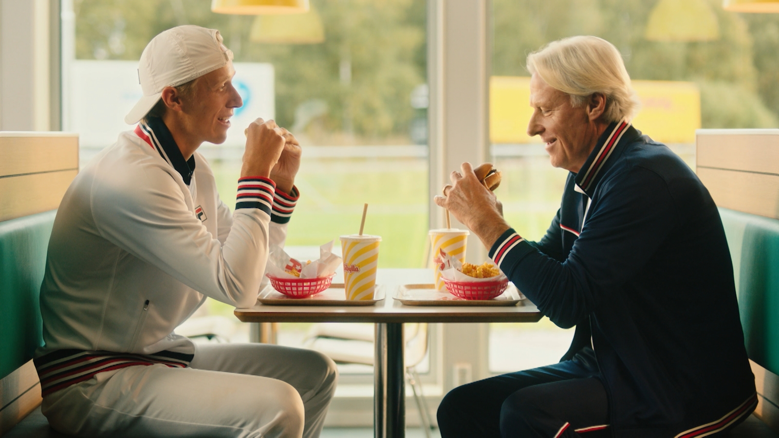 a couple of men sitting at a table eating food