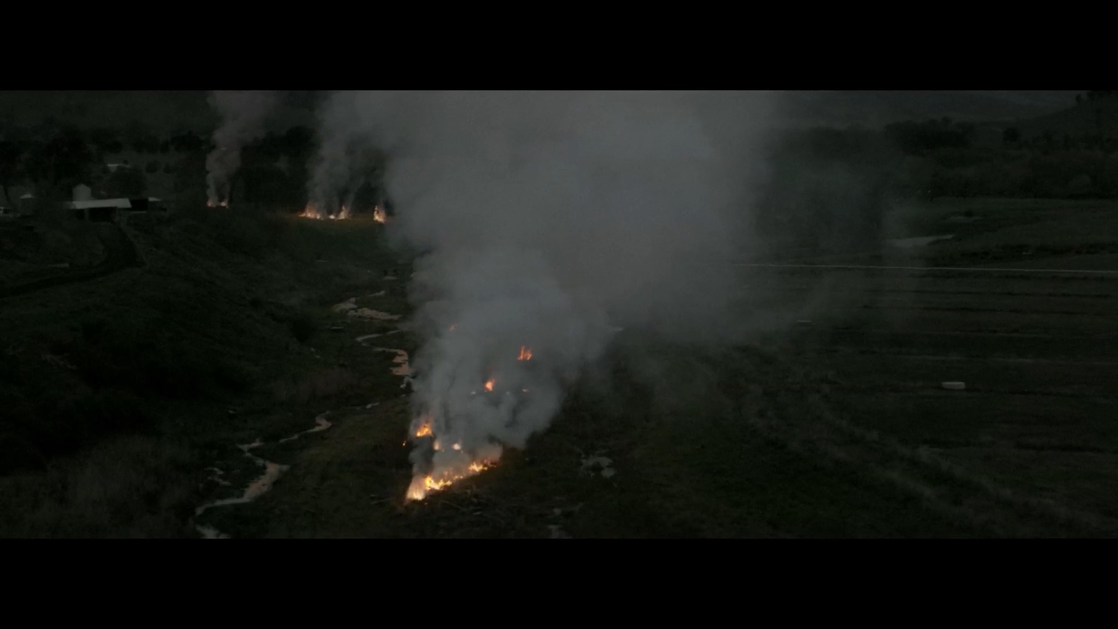 a large amount of smoke billowing out of a field