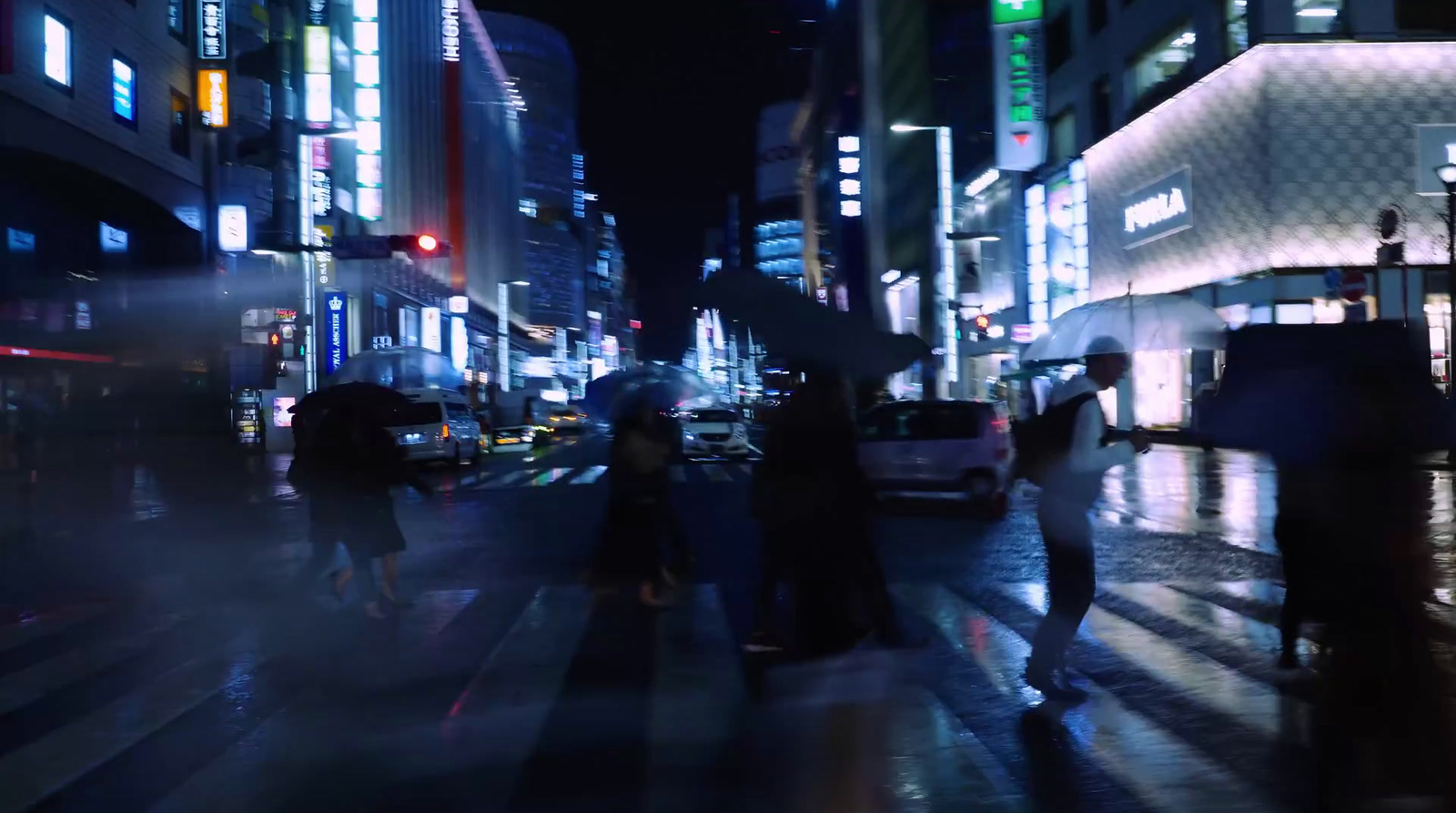 a group of people walking down a street at night