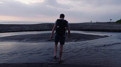 a man with a backpack is walking in the water