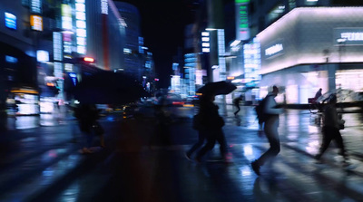 a group of people walking down a street at night