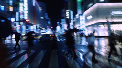 a blurry photo of people crossing the street at night