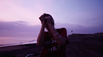 a man standing next to a bike on a beach