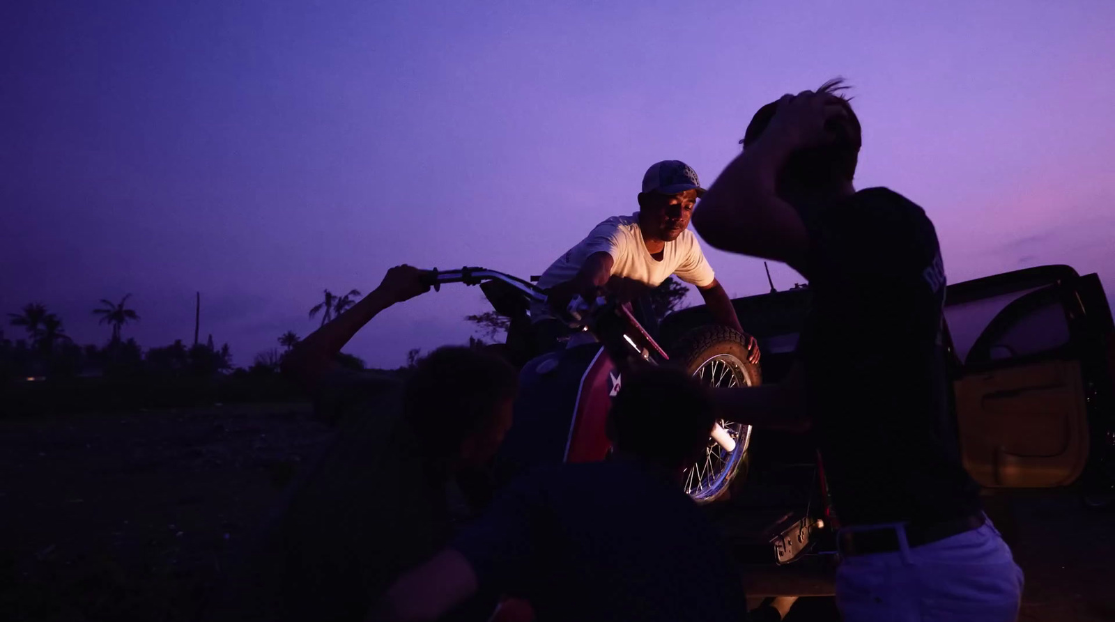 a group of people standing around a motorcycle