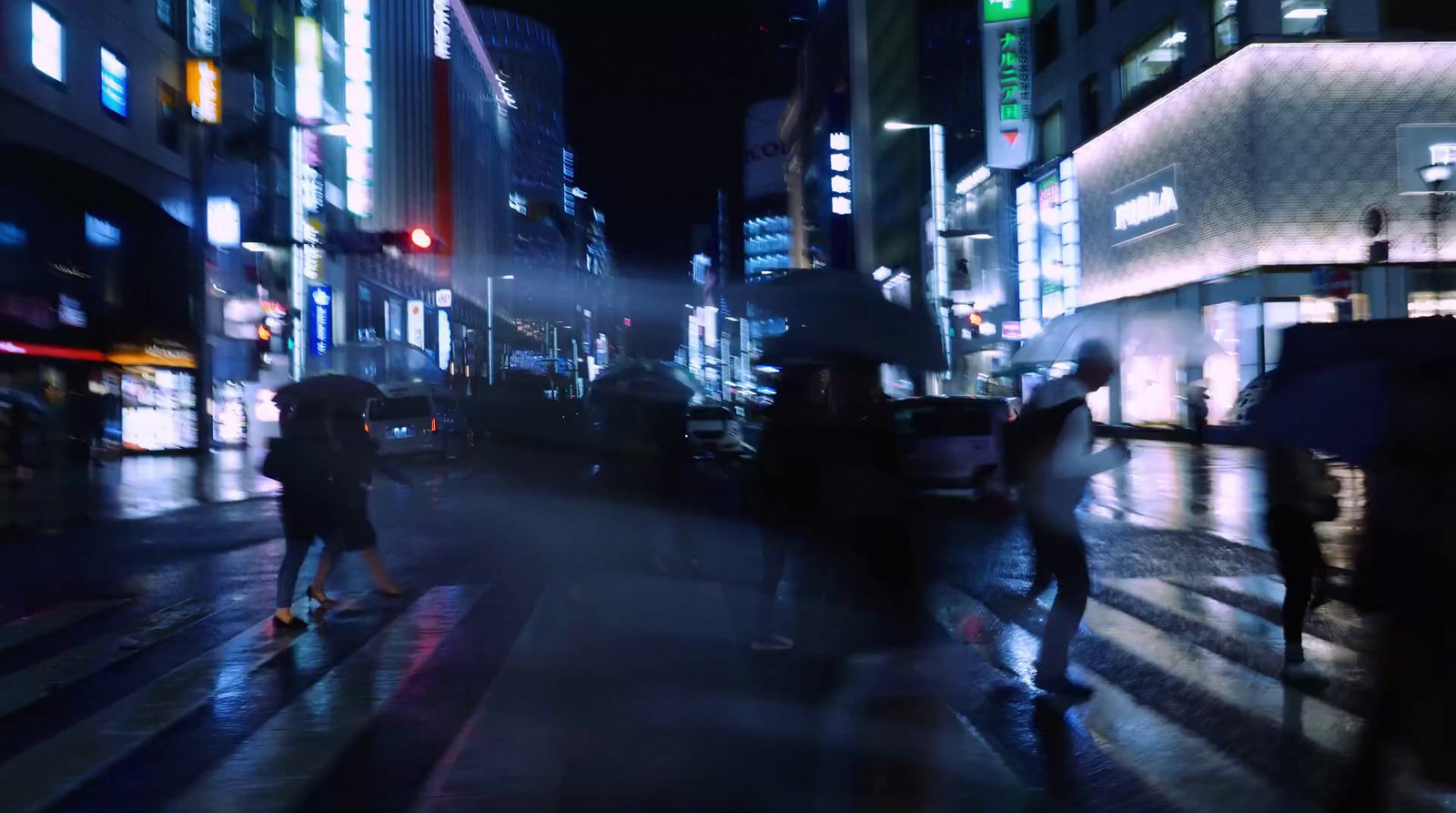 a blurry photo of people walking down a city street at night