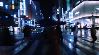 a group of people walking down a street at night