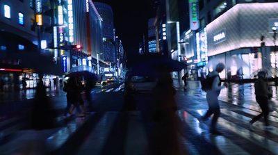 a group of people walking down a street at night