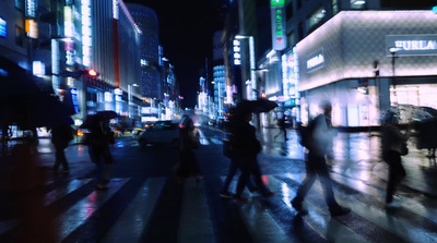 a group of people walking across a street at night